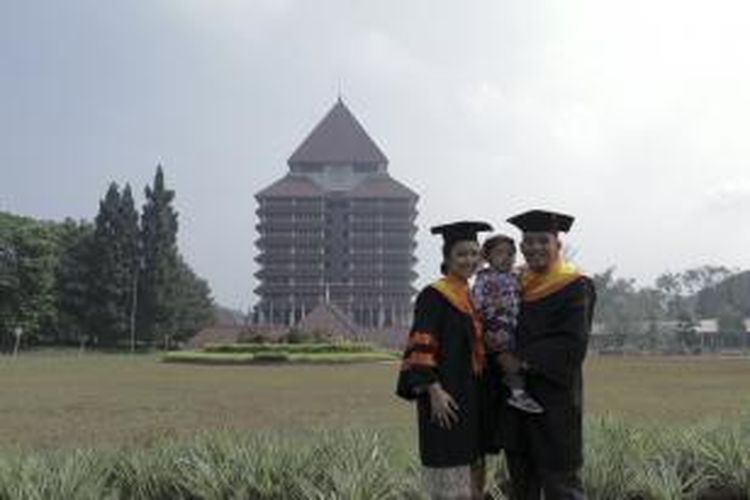 Mantan pebulu tangkis nasional, Luluk Hadiyanto mengenakan baju wisuda, berpose bersama istri dan anaknya, Minggu (31/8/2013)