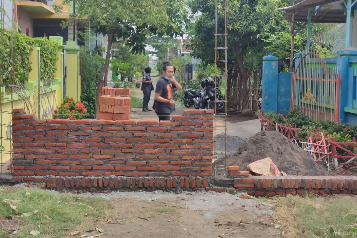 Warga menutup akses jalan dengan membangun tembok. Foto diambil sebelum tembok dibongkar. 