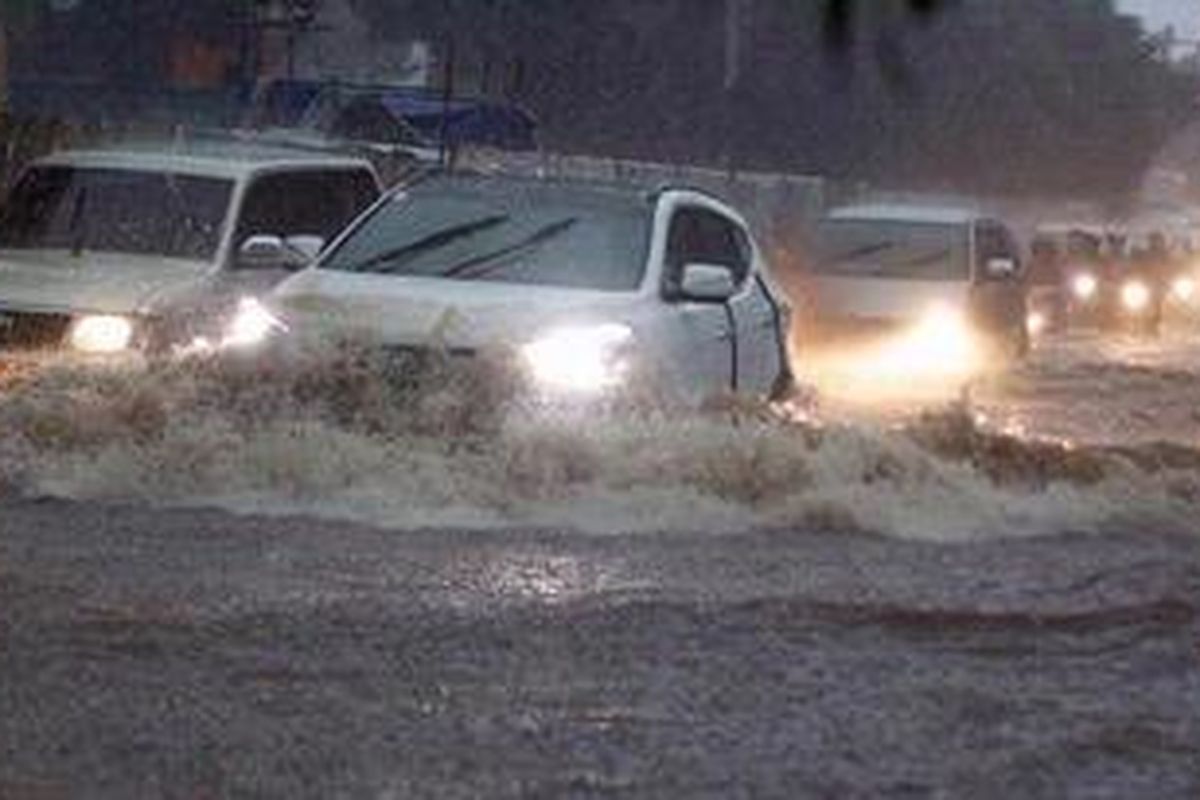 Kendaraan menembus genangan air di Jalan Satrio, Jakarta Selatan, Rabu (6/2/2013). Buruknya sistem drainase membuat banyak genangan air meski hujan hanya berlangsung cepat.  