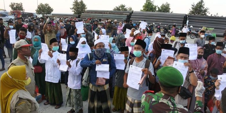 Warga memperlihatkan surat keterangan bebas Covid-19 kepada petugas di Pelabuhan Jangkar, Situbondo, Jawa Timur, Senin (07/06\).