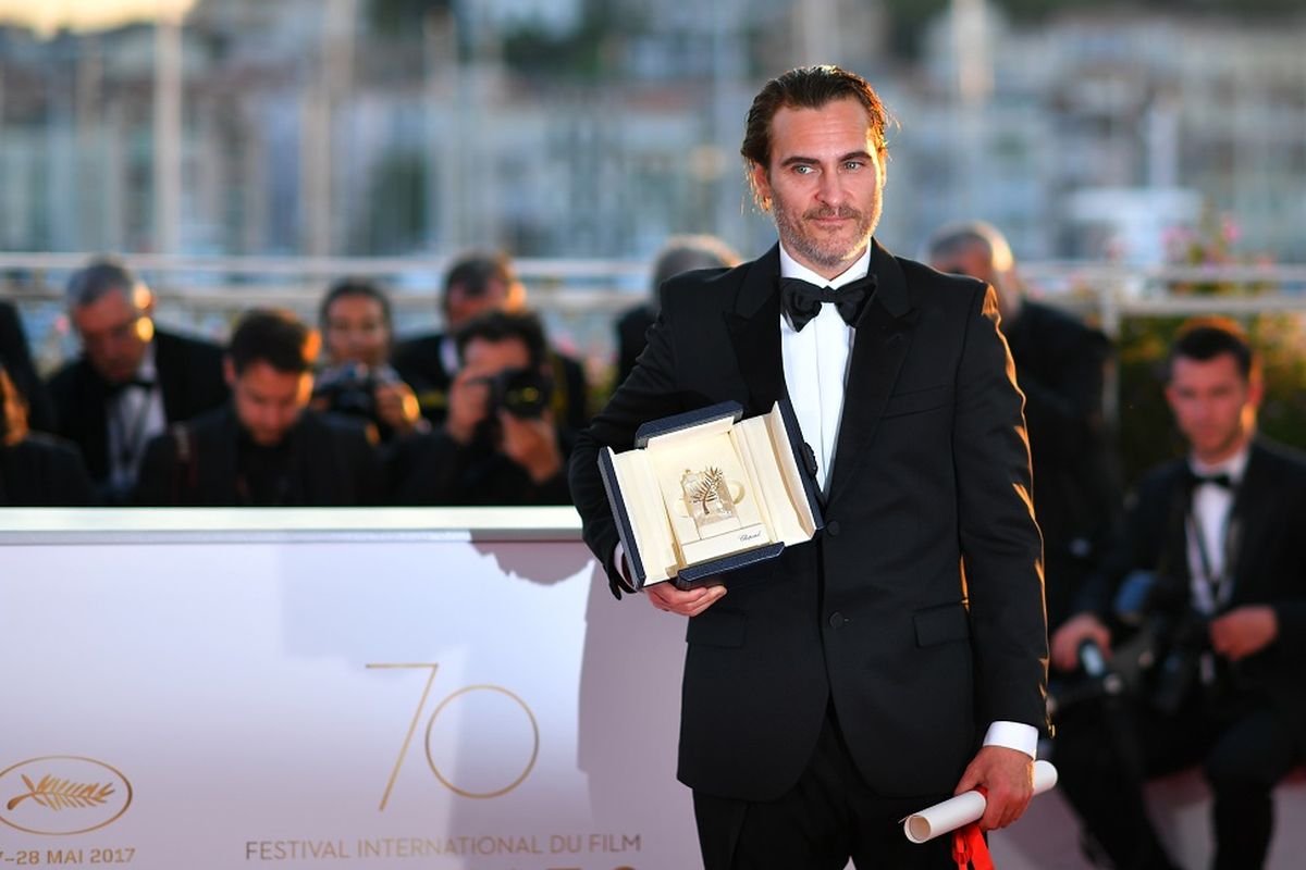 Aktor Amerika Joaquin Phoenix berpose dengan penghargaan yang diterimanya sebagai aktor terbaik dalam Festival Film Cannes 2017 di Cannes, Perancis, Minggu (28/5/2017).