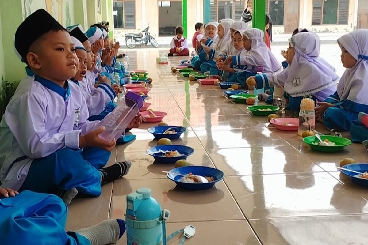 Siswa bersemangat menyantap menu yang disediakan oleh pihak sekolah di Pamekasan, Jawa Timur, Selasa (23/9/2025).