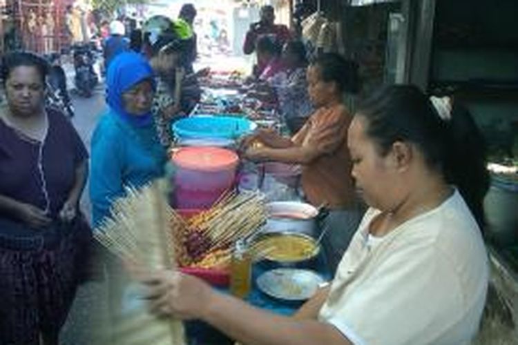 Seorang pedagang sate jeroan sapi tengah menjajakan dagangannya di pasar kaget Kampung Jawa, Denpasar.