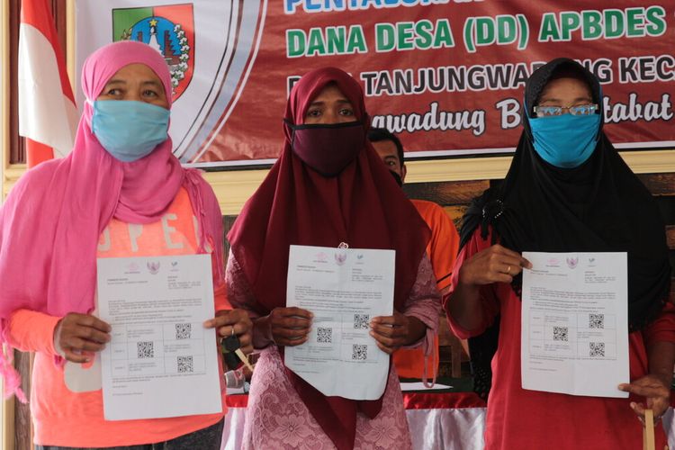 Tiga warga Desa Tanjung Wadung, Kecamatan Kabuh, Kabupaten Jombang, Jawa Timur, menunjukkan surat panggilan pencarian bansos tunai dari Kemensos RI, di Kantor Desa Tanjung Wadung, Minggu (17/5/2020).