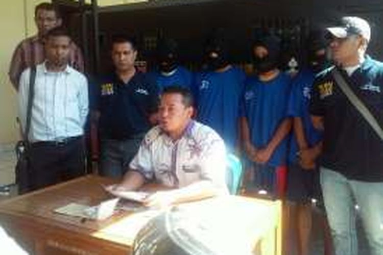 Kepala Satuan Reskrim Kepolisian Resor Kupang Kota, AKP Didik Kurnianto (duduk) saat memberikan keterangan pers kepada wartawan terkait penangkapan terhadap 4 orang pelaku (belakang berbaju biru) pencurian kendaraan bermotor yang diselundupkan ke Timor Leste