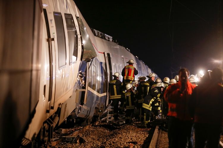 Petugas pemadam kebakaran berada di sisi kereta yang mengalami kecelakaan pada 5 November 2017, di Meerbusch-Osterath, di barat Jerman. Setidaknya 47 ornag terluka dalam insiden ini. (AFP/Ina Fassbender)