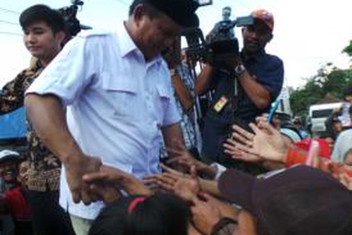 Calon presiden Prabowo Subianto naik ke atas mobil bak terbuka untuk menyapa warga saat blusukan ke pasar ciparay, Kabupaten Bandung, Jawa Barat, Kamis (3/7/2014)
