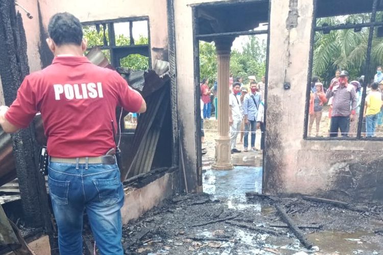 Foto: Usai api berhasil dipadamkan Polisi  melakukan pemeriksaan di dalam rumah terbakar di Huta I, Nagori Lumban Gorat, Kabupaten Simalungun, Jumat (2/10/2020). Korban Hermin Sianipar ditemukan tergeletak dalam keadaan meninggal dunia di ruang tengah. (Dok: Polsek Dolok Panribuan)