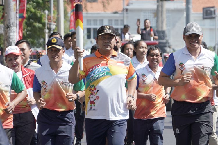 Wali Kota Semarang Hendrar Prihadi berlari membawa obor ASEAN School Games 2019 dari Lawang Sewu menuju Balaikota Semarang, Rabu (17/7/2019).