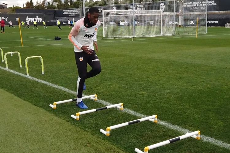 Pemain Valencia, Geoffrey Kondogbia, melintasi halang rintang di lapangan latihan tim.