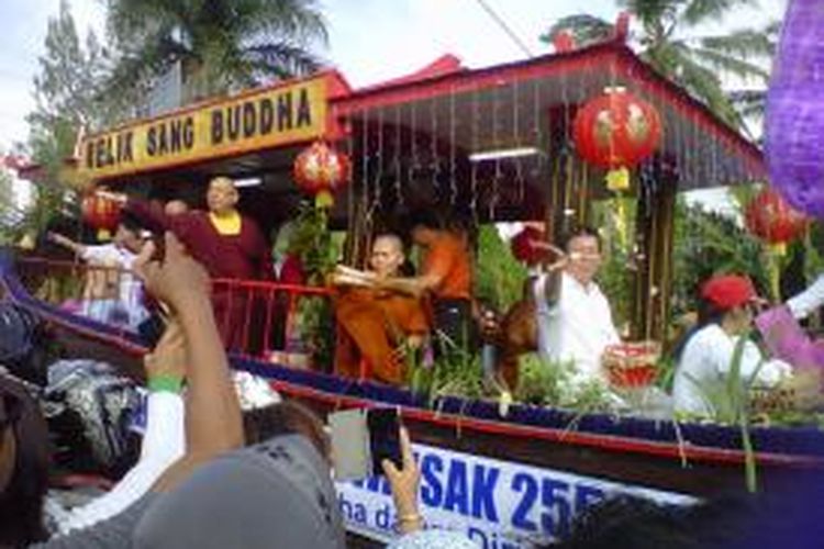 Mobil hias membawa relik Buddha, tampak sejumlah Bhiksu dan Bhiksuni memercikkan air berkah kepada masyarakat yang menyaksikan kirab Waisak 2559 BE menuju Candi Borobudur, Selasa (2/6/2015).
 
 
