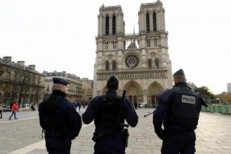 Polisi berjaga-jaga di depan gedung Notre-Dame de Paris Cathedral di Paris, sehari setelah aksi teror pada pada 13 November malam yang menewaskan lebih dari 100 orang.