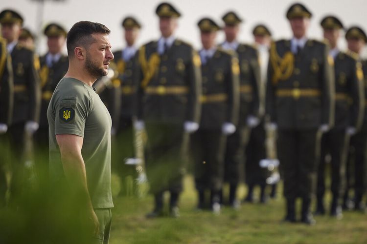 Presiden Ukraina Volodymyr Zelensky berdiri di depan barisan tentara saat ia tiba untuk perayaan Hari Bendera Negara di Kyiv, Ukraina, Selasa (23/8/2022). 