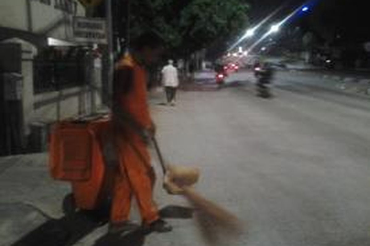 Para penyapu jalan mulai bekerja sejak dini hari. Salah satu penyapu di Jalan Mampang Prapatan, Jakarta Selatan, Selasa (19/8/2014).