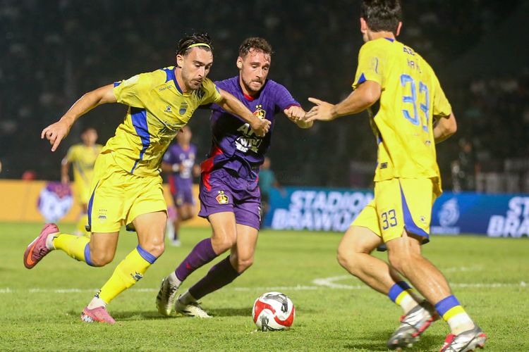 Penyerang Persib Bandung Andrew Jung menguasai bola diganggu bek Persik Kediri Francisco Carneiro pada laga pekan ke-16 Super League 2025-2026, Senin (5/1/2025) di Stadion Brawijaya, Kediri. 