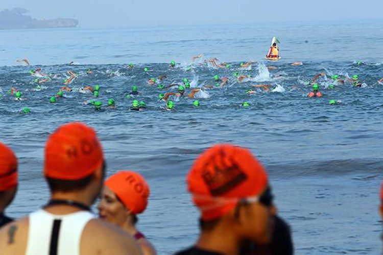 Peserta Herbalife Bali International Triathlon (HBIT) 2015 berenang melintasi rute yang telah ditentukan di kawasan Pantai Jimbaran, Bali, Minggu (25/10/2015).