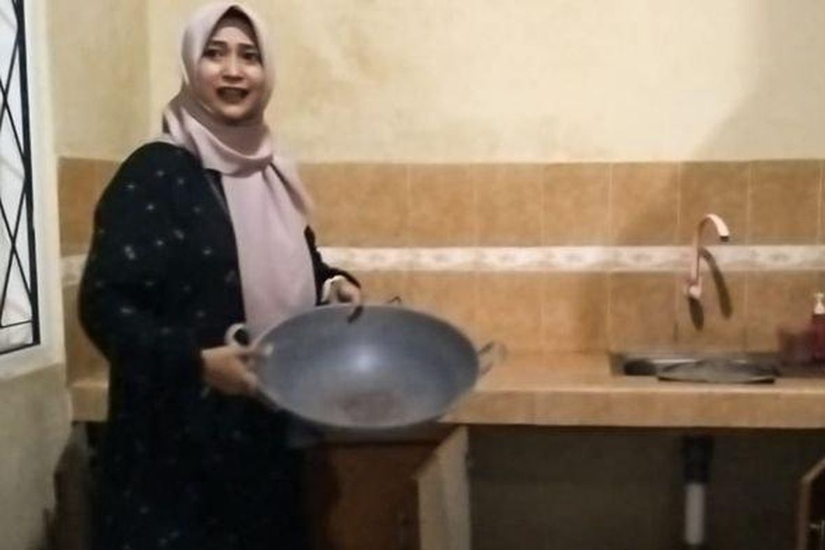 Rini menunjukkan kuali yang digunakan pencuri untuk menutupi diri saat sembunyi ketika masuk rumah kosong di Tasikmalaya, Kamis (6/6/2024). 

