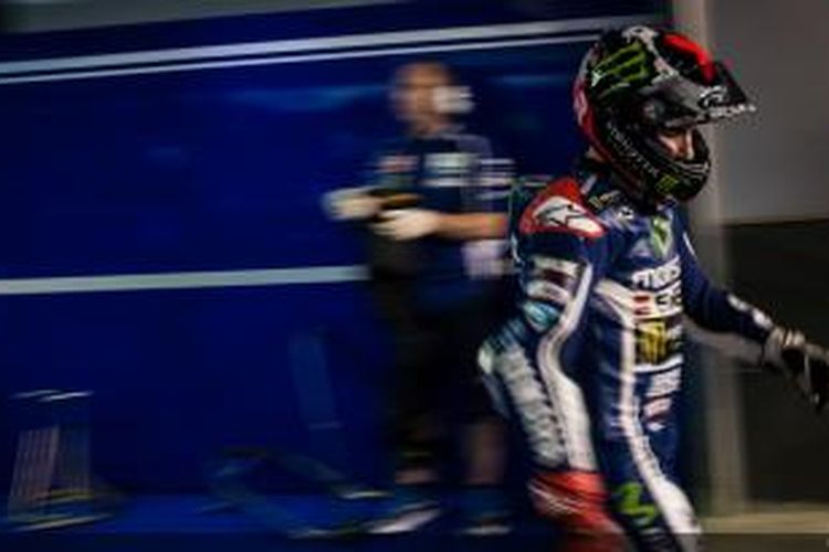 Pebalap Movistar Yamaha asal Spanyol, Jorge Lorenzo, berjalan di pit Sirkuit Losail pada sesi latihan bebas ketiga, Jumat (21/3/2014).