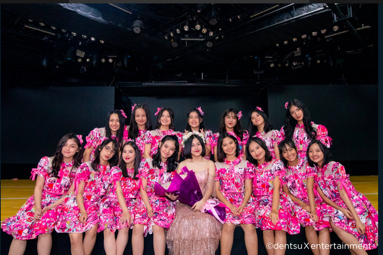 Member JKT48, Kyla (tengah membawa buket bunga), berfoto dengan member lain pada pertunjukan terakhirnya sebagai anggota dari grup idola tesebut.