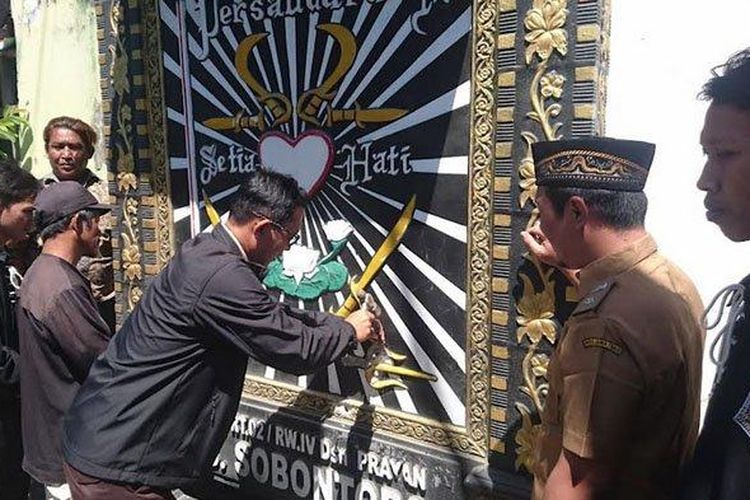 Tokoh PSHT mulai menghapus logo PSHT di tugu pencak silat yang ada di Dusun Karanggude, Desa Sobontoro, Kecamatan Boyolangu, Kabupaten Tulungagung.  (Surya.co.id)