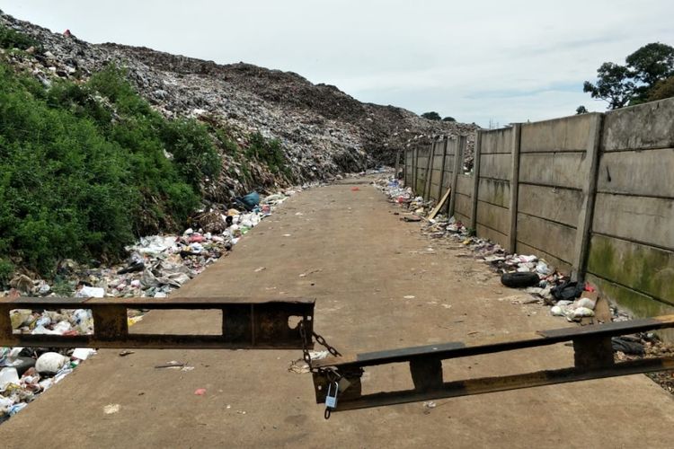 Jalan akses bagi truk sampah menuju TPA Burangkeng digembok warga Desa Burangkeng, Kamis (14/3/2019). Mereka menuntut Pemkab Bekasi membayar kompensasi  terkait keberadaan TPA itu.