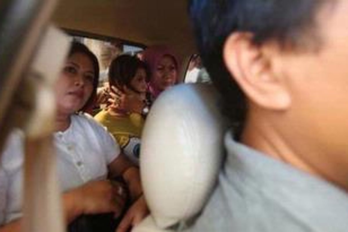 Novi Amalia (berkaus kuning) dipindahkan dari Polsek Metro Tamansari hendak dibawa ke Rs Polri untuk diperiksa kejiwaannya, Jakarta, Jumat (12/10/2012). Pada kamis (9/10/2012) sore, Novi yang mengendarai Honda Jazz warna merah menabrak sejumlah warga sipil dan polisi lalu lintas di Jalan Gajah Mada.

