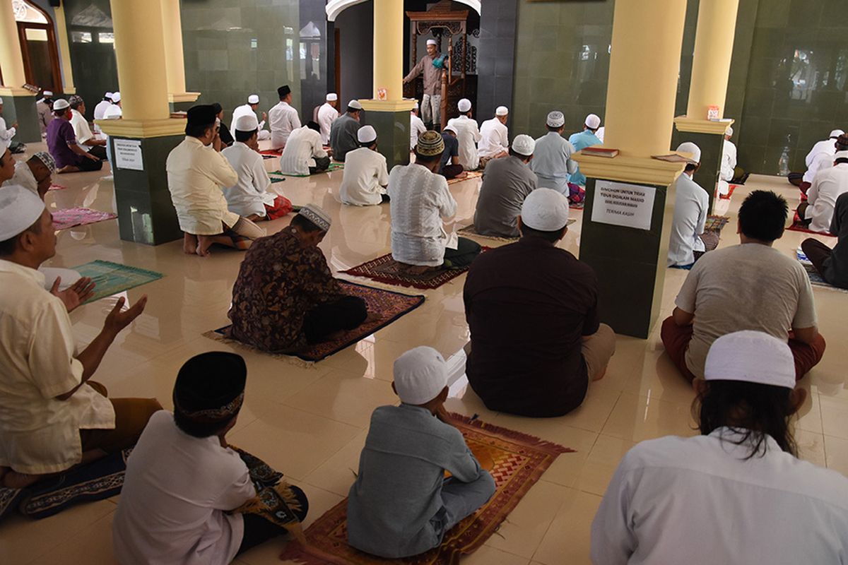 Umat Islam mendengarkan khotbah sebelum menunaikan Shalat Jumat dengan menjaga jarak fisik di Masjid Jami Daarul Muslimin, Pulo Kalibata, Jakarta, Jumat (17/4/2020). Di masa Pembatasan Sosial Berskala Besar (PSBB), sejumlah masjid masih menggelar Shalat Jumat meskipun Majelis Ulama Indonesia (MUI) dan Pemprov DKI Jakarta telah mengimbau untuk menghentikan sementara kegiatan keagamaan di rumah ibadah guna menekan penyebaran COVID-19.