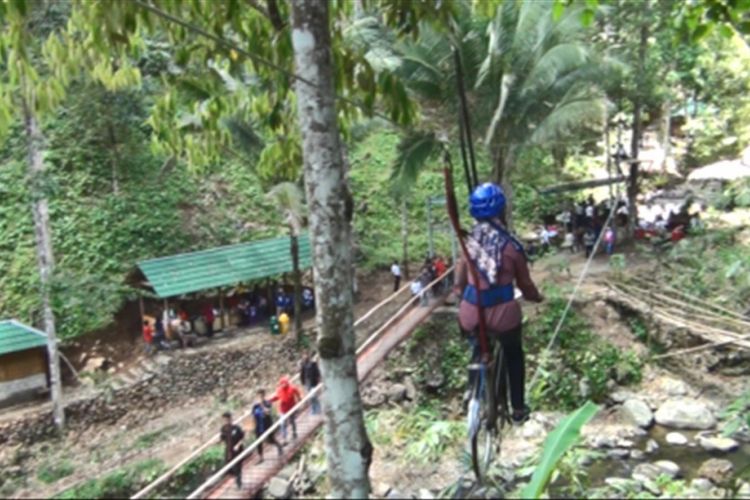 Wisatawan tengah bersepeda udara di kawasan wisata alam Banyu Nget Trenggalek