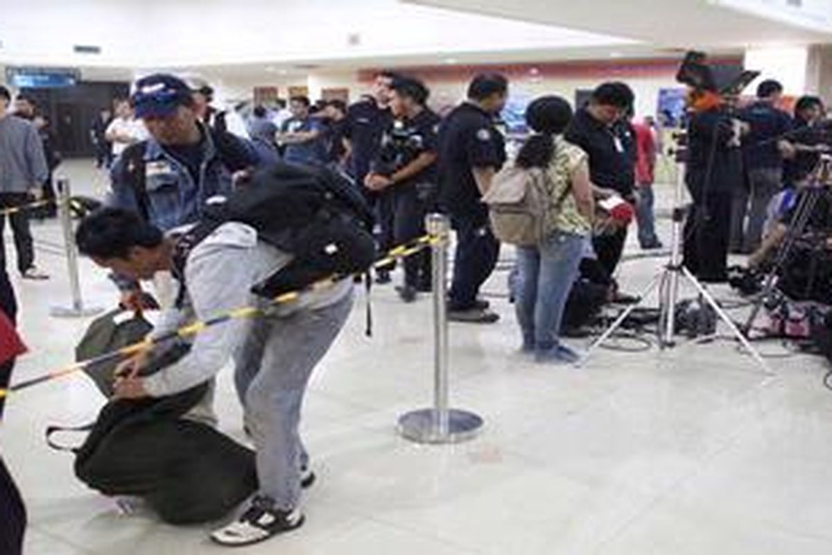 Posko crisis center kecelakaan pesawat Sukhoi Superjet 100 yang berada di ruang kedatangan Bandara Halim Perdanakusuma, Jakarta, membuat penumpang penerbangan sipil berbagi tempat saat mengambil barang di bagasi, Kamis (10/5/2012). 