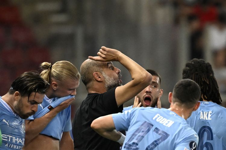 Manajer Manchester City Pep Guardiola berbicara kepada para pemainnya saat istirahat pada pertandingan Piala Super Eropa antara Man City vs Sevilla di Stadion Georgios Karaiskakis di Piraeus pada 16 Agustus 2023. (Foto oleh Aris MESSINIS / AFP)