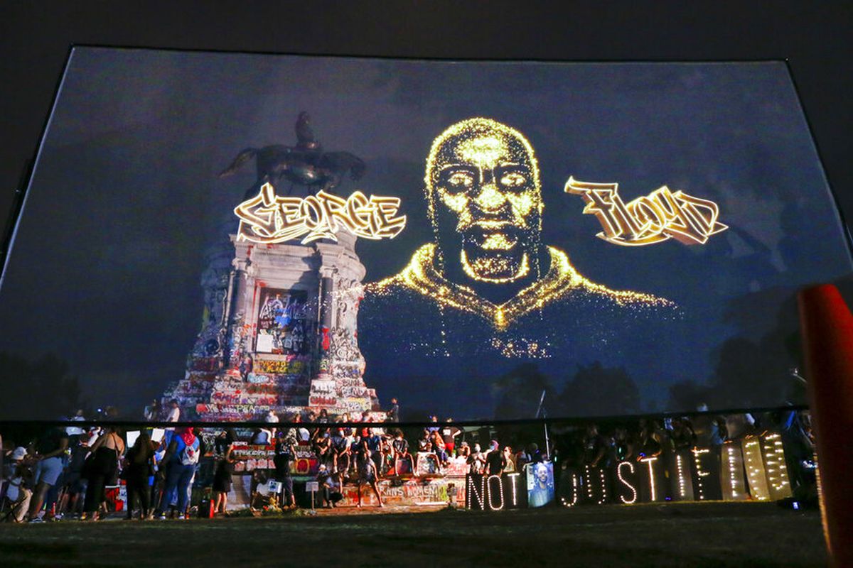 An image of George Floyd is projected on a screen in front of the statue of Confederate General Robert E. Lee on Monument Avenue Tuesday July 28, 2020, in Richmond, Va. Change.org and the George Floyd Foundation officially launched A Monumental Change: The George Floyd Hologram Memorial Project in Richmond, the capital of the Confederacy (AP Photo/Steve Helber)