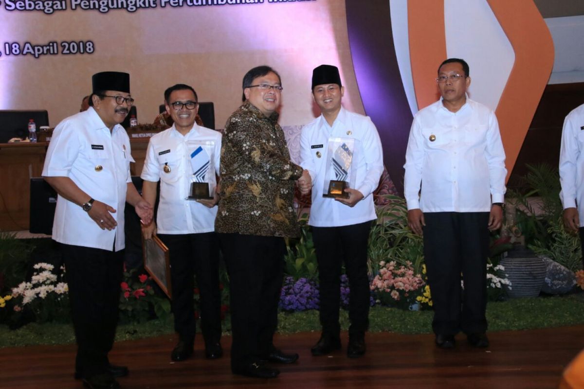 Menteri Perencanaan Pembangunan Nasional (PPN)/Kepala Bappena,s Bambang Brodjonegoro, didampingi Gubernur Jawa Timur, Soekarwo, menyerahkan penghargaan Perencanaan Pembangunan Daerah kepaa Plt. Bupati Trenggalek, Mochammad Nur Arifin, di Surabaya dalam acara Musrenbang Provinsi Jawa Timur, Kamis (19/4/2018)
