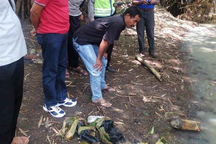 AMATI-Aparat Polsek Saradan-Madiun sementara mengamati peluru meriam yang ditemukan  Ninik Suhartini di pinggir sungai Dusun Nampurejo, Desa Sugihwaras, Kecamatan Saradan, Kabupaten Madiun, Sabtu ( 4 / 3 / 2017) siang. 