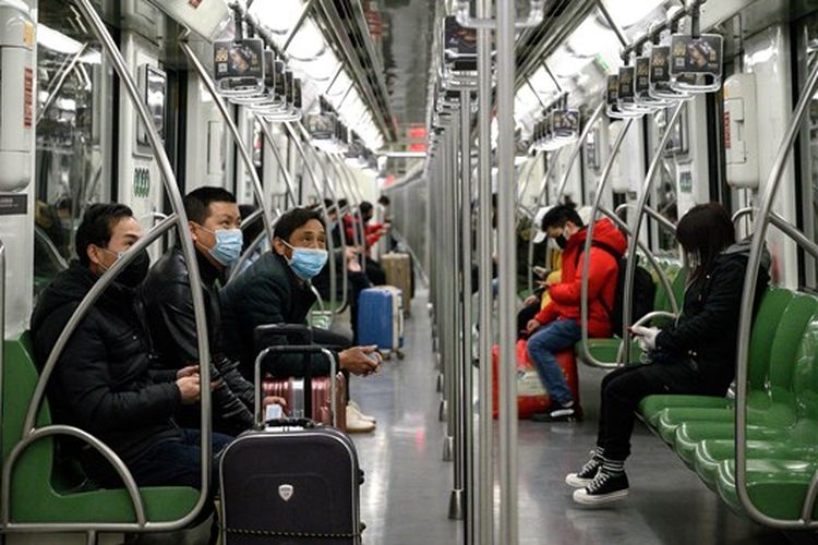 Penumpang kereta di Shanghai, China Memakai Masker Pelindung pada Minggu, 9 Februari 2020