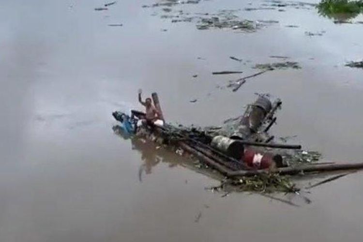 Pria hanyut naik gethek (rakit) di Sungai Brantas di bawah Jembatan Lama Kota Kediri.