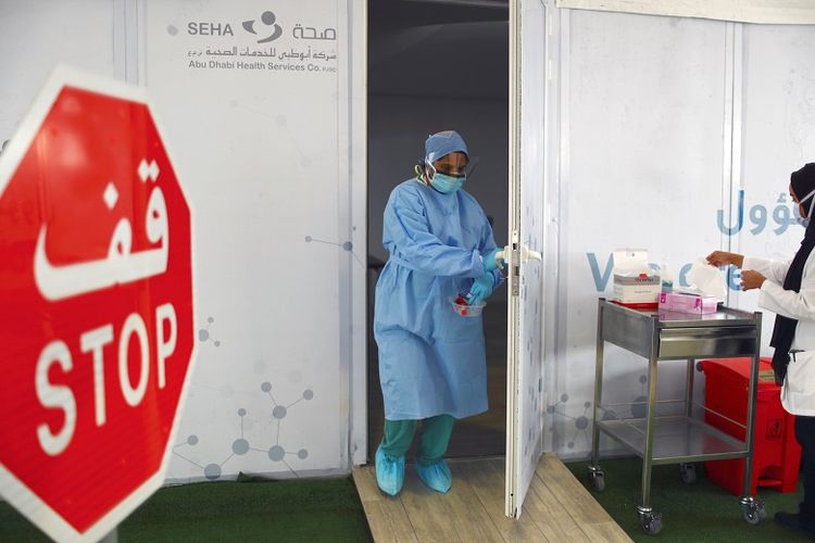 Seorang anggota staf medis membawa swab yang diuji selama pengujian penyakit drive-thru coronavirus (COVID-19) di pusat skrining di Abu Dhabi, Uni Emirat Arab 30 Maret 2020.