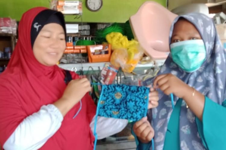 Siswi kompetensi keahlian tata busana SMKN 1 Sayung Kabupaten Demak, Jateng, membagikan masker karya mereka sendiri hasil dari pembelajaran daring, untuk mengantisipasi penyebaran wabah covid 19, Jumat (27/3/2020)