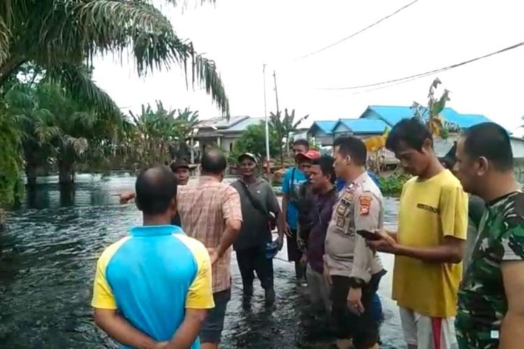 Petugas kepolisian dan warga saat mengecek lokasi dua anak tewas tenggelam di lokasi banjir, di Kelurahan Pangkalan Kerinci, Kecamatan Pangkalan Kerinci, Kabupaten Pelalawan, Riau, Selasa (23/1/2024).