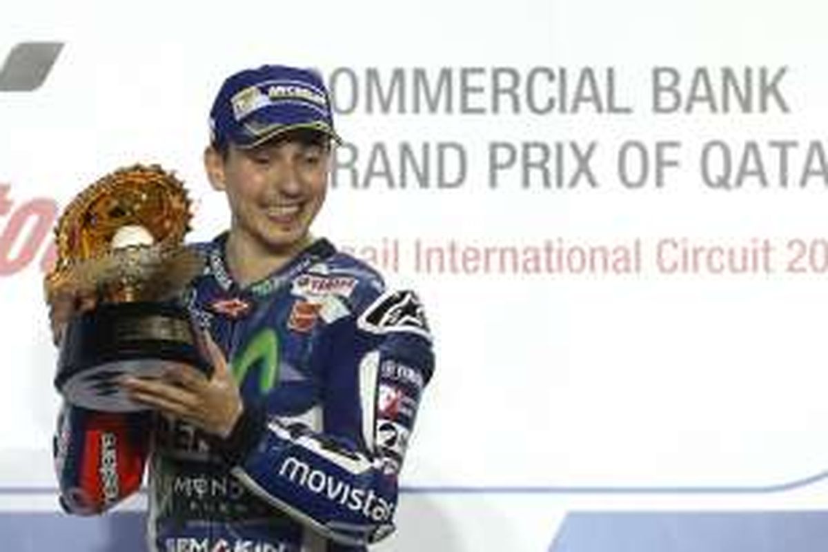 Pebalap Movistar Yamaha asal Spanyol, Jorge Lorenzo, merayakan kemenangan di atas podium Sirkuit Losail setelah memenangi balapan GP Qatar, Minggu (20/3/2016).