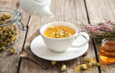 Ilustrasi menuangkan teh chamomile.