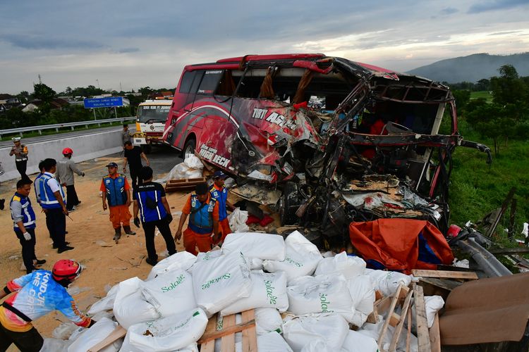 Sejumlah petugas melakukan proses evakuasi bus pariwisata yang terlibat kecelakaan di Tol Malang KM 77+200 Jalan Tol Pandaan-Malang, Lawang, Kabupaten Malang, Jawa Timur, Senin (23/12/2024). Berdasarkan data temuan awal Polres Malang, kecelakaan bus pariwisata dan truk tersebut menyebabkan empat orang meninggal dunia. 