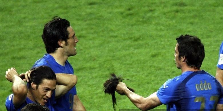 Bek sayap timnas Italia Massimo Oddo (kanan) memegang potongan rambut gelandang Gli Azzurri Mauro Camoranesi (kiri) setelah laga final Piala Dunia 2006 melawan Perancis di Stadion 