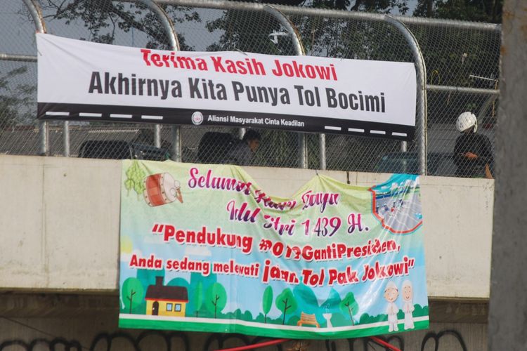 Spanduk bertuliskan Terima Kasih Jokowi, Akhirnya Kita Punya Bocimi dan  Pendukung #2019GantiPresiden, Anda sedang melewati Jalan Tol Pak Jokowi terpasang di tol fungsional Bogor-Ciawi-Sukabumi (Bocimi), Senin (11/6/2018).