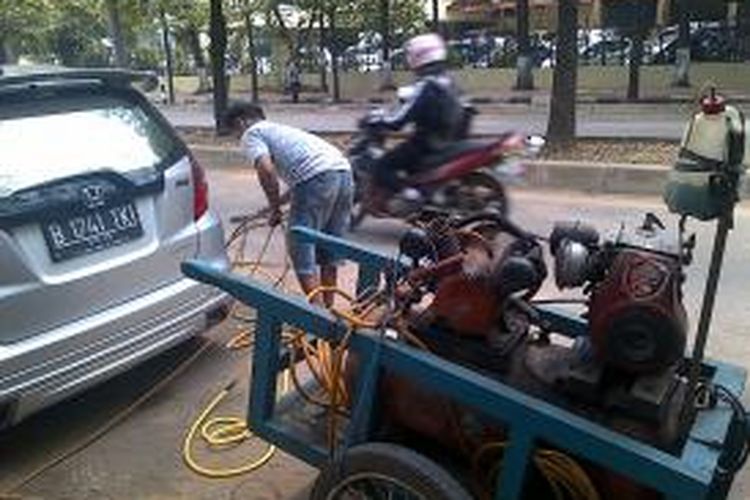 Penyedia jasa tambal ban dari Jalan Sriwijaya 4 sengaja dipanggil ke Jalan Raden Patah 1 untuk memasang pentil dan memompa ban kendaraan yang digembosi dalam penertiban parkir liar di kawasan Kebayoran Baru, Jakarta Selatan, (7/10/2013).
