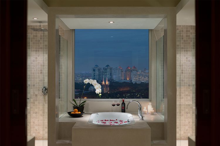 Bathtub dengan permandangan ke kota yang tersedia di kamar kelas Club Suite, Spark Luxe Jakarta