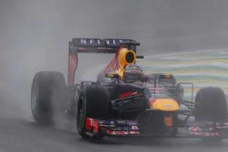 Pebalap Red Bull Racing asal Jerman, Sebastian Vettel  memacu mobilnya di Sirkuit Interlagos yang basah karena hujan pada sesi kualifikasi GP Brasil. Sabtu (23/11/2013).