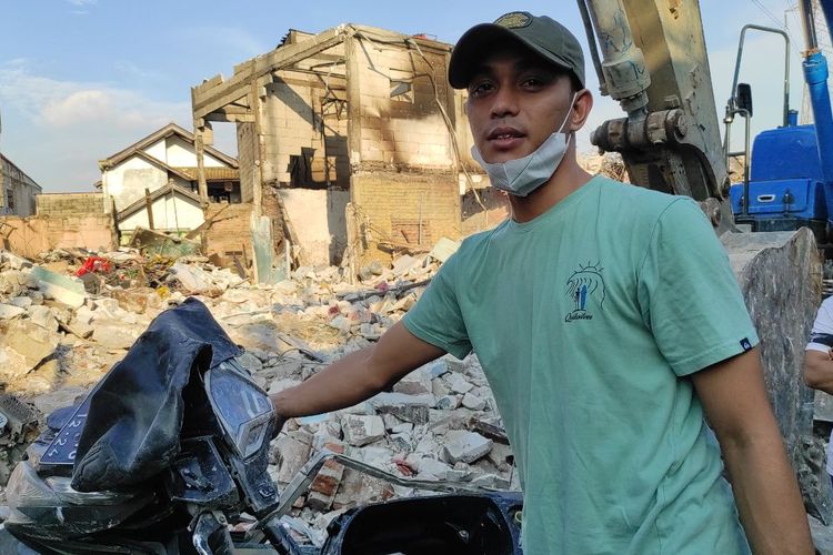 Putra Supriyadi (28) saat memindahkan motor Honda Vario dari tumpukan reruntuhan di Jalan Tanah Merah Bawah, Koja, Jakarta Utara, Minggu (5/3/2023) 