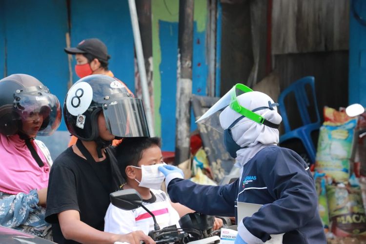 Petugas Satgas Covid-19 di Kutai Kartanegara, Kaltim saat membagikan masker kepada pengendara di Tenggarong belum lama ini. 