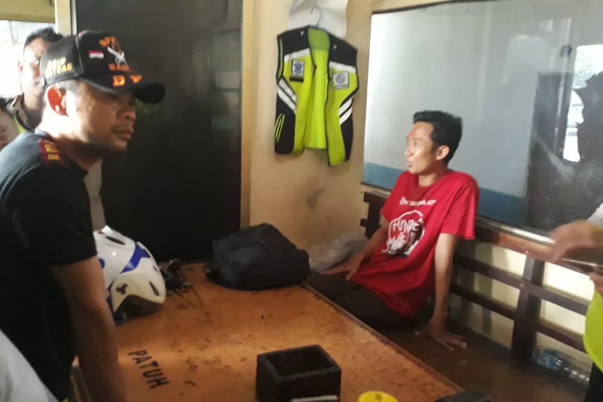 Seorang pemuda berinisial M (38), berbaju merah, diamankan oleh Satlantas Jakarta Barat di dekat Pos Lantas Cengkareng, Jakarta Barat, Rabu (23/10/2019). M diketahui membawa senjata tajam.