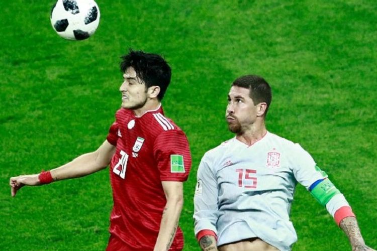 Sardar Azmoun dan Sergio Ramos berduel di udara dalam memperebutkan bola pada pertandingan Iran vs Spanyol di Kazan Arena, 20 Juni 2018. 